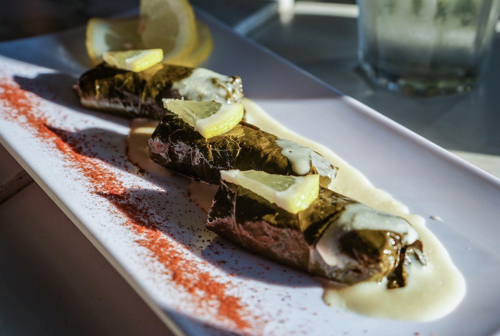 Dolmades — hojas de parra rellenas, bañadas en salsa de limón