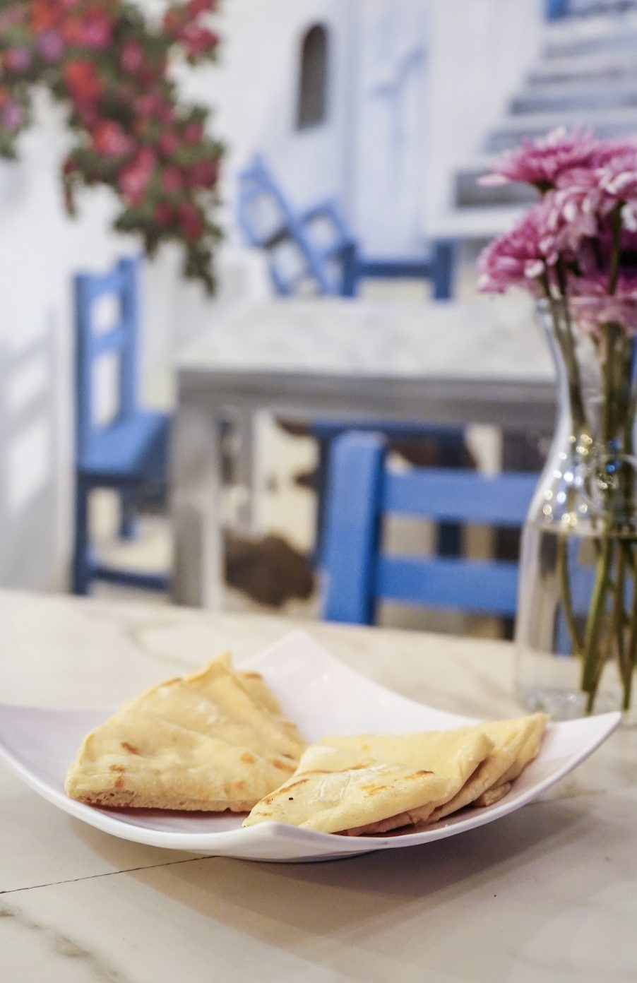 Mesa de OPA con pan pita recién horneado y flores